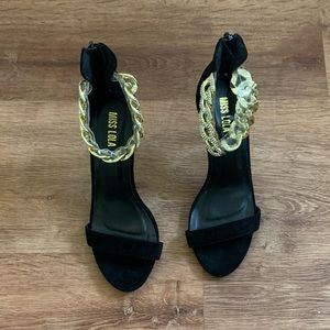 Black heels with gold chain design.